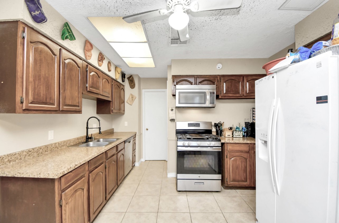 712 Meadowick Drive Baytown, TX 77521 - Photo 18 of 21 a kitchen with stainless steel appliances granite countertop a sink a stove a refrigerator and a cabinets