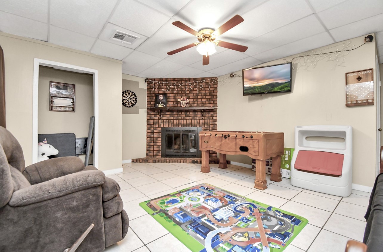 712 Meadowick Drive Baytown, TX 77521 - Photo 8 of 21 a living room with furniture a fireplace and a flat screen tv
