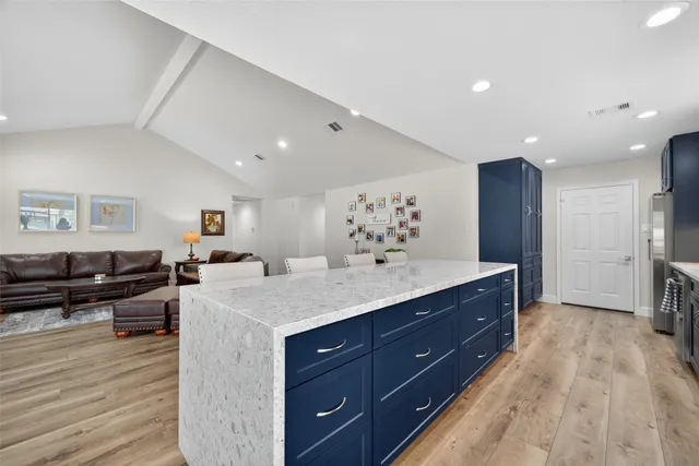 a spacious bathroom with a granite countertop sink and a mirror