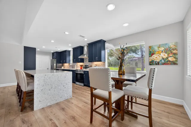 a dining room with furniture a large window and wooden floor