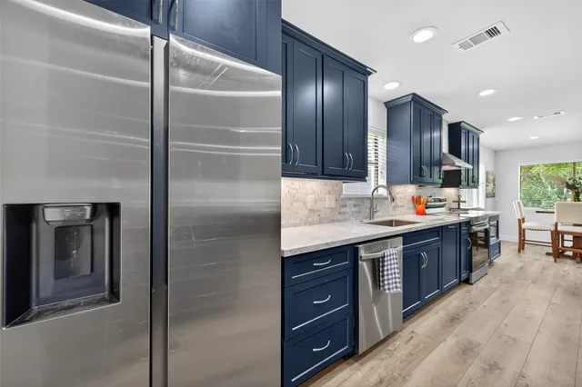a large kitchen with stainless steel appliances a large counter top