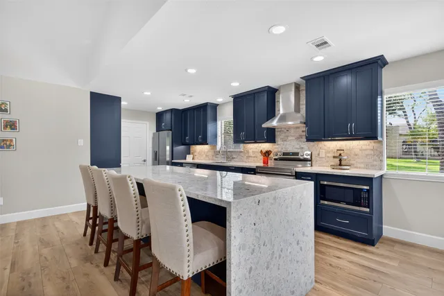 a kitchen with a table chairs refrigerator microwave and cabinets