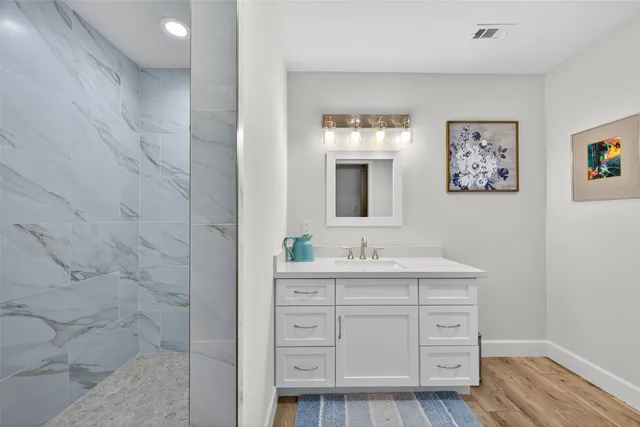 a bathroom with a double vanity sink a mirror and a shower