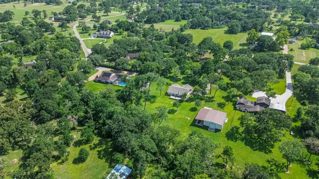 an aerial view of residential house with outdoor space and trees all around
