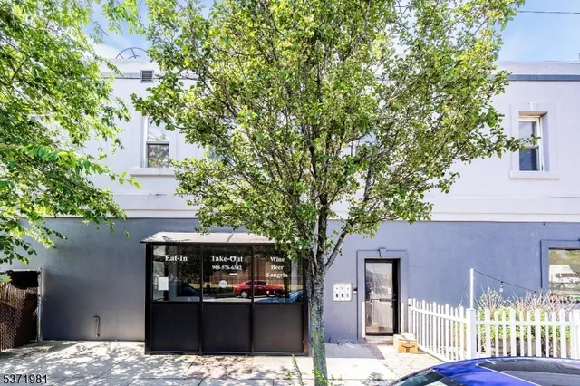 a view of a house with a tree in front of it