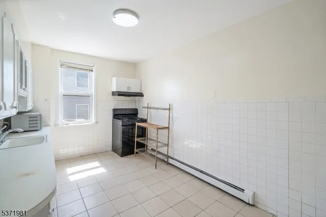 a kitchen with a refrigerator and a stove top oven