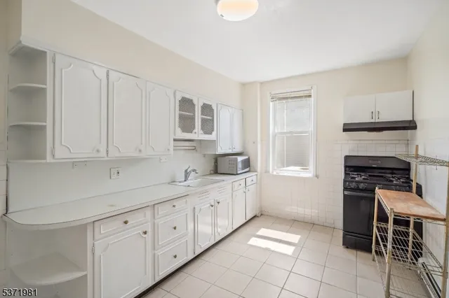 a kitchen with white cabinets and appliances