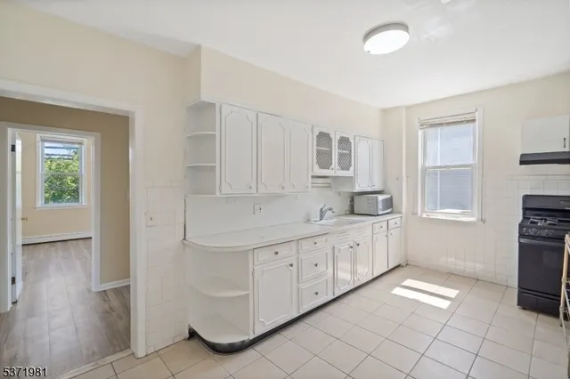 a large white kitchen with cabinets