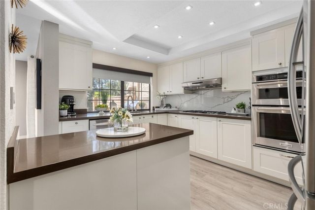a kitchen with kitchen island granite countertop white cabinets white appliances and granite counter tops
