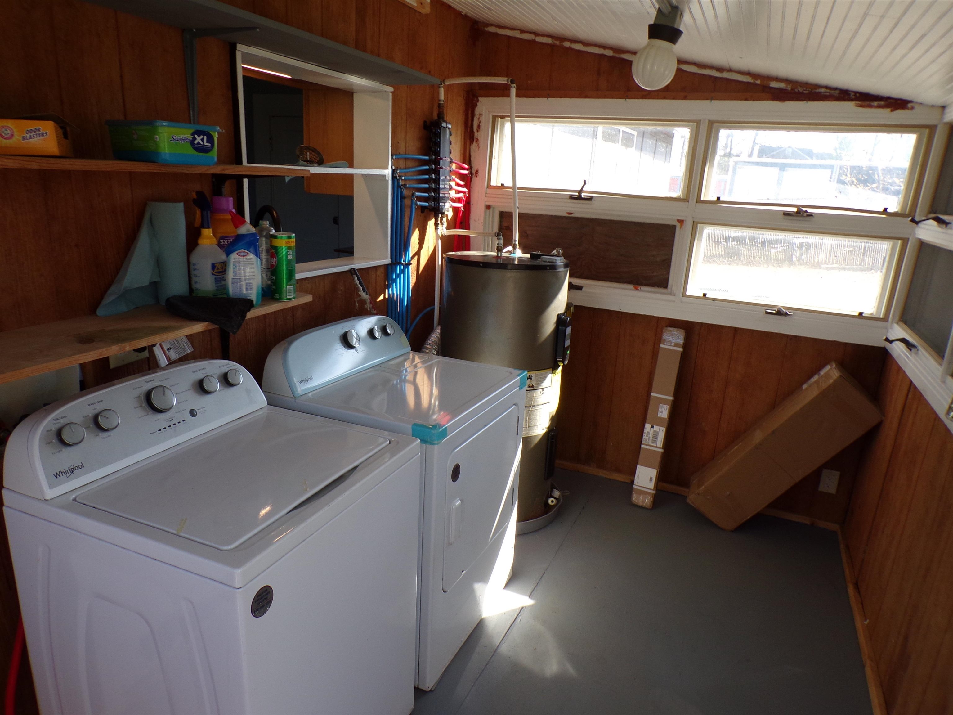 5950 Highway 57 Counce, TN 38326 - Photo 18 of 23 Laundry area with electric water heater, lofted ceiling, wood walls, and washing machine and clothes dryer