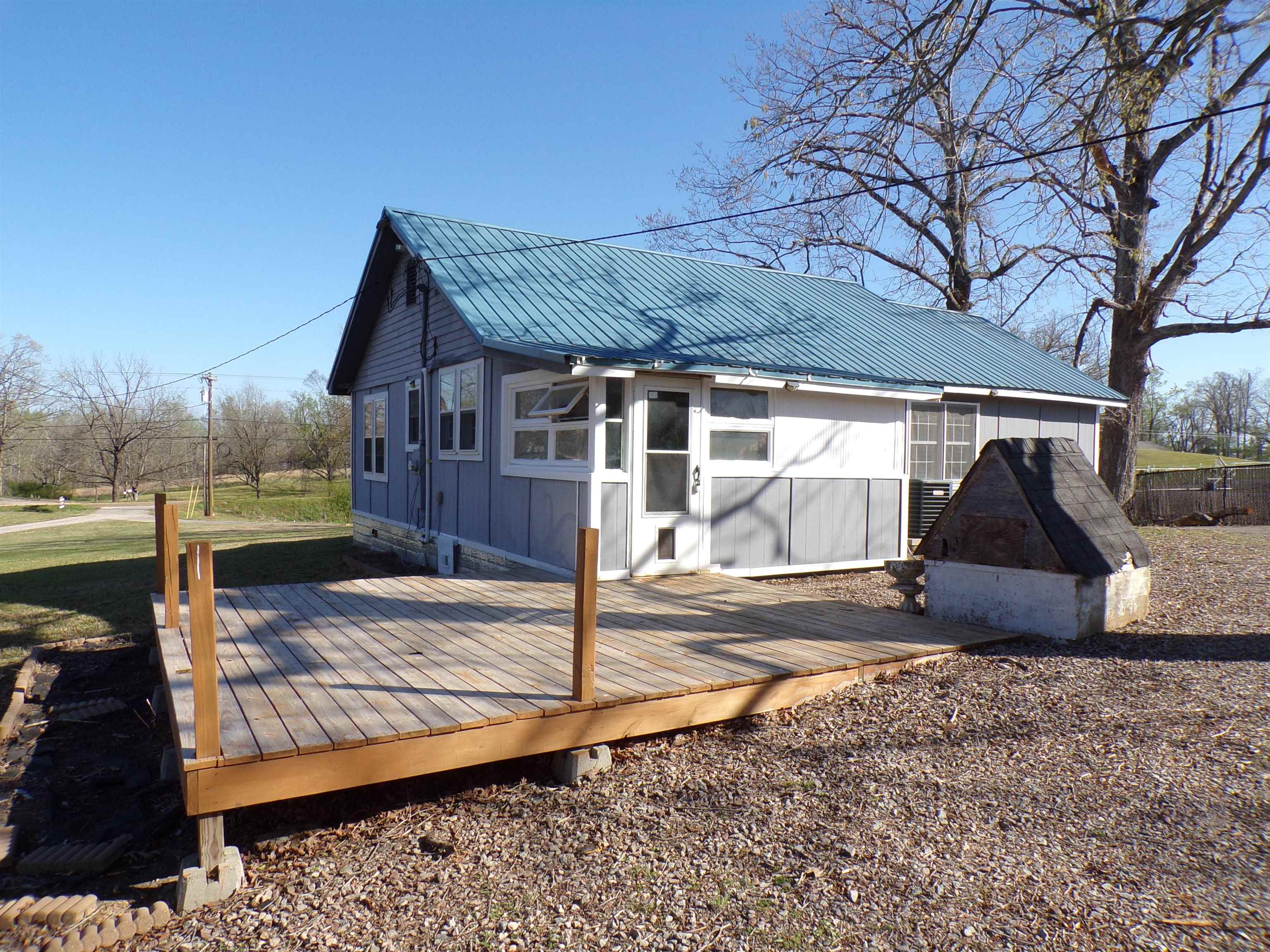 5950 Highway 57 Counce, TN 38326 - Photo 19 of 23 Rear view of property with a wooden deck, a metal roof, and board and batten siding