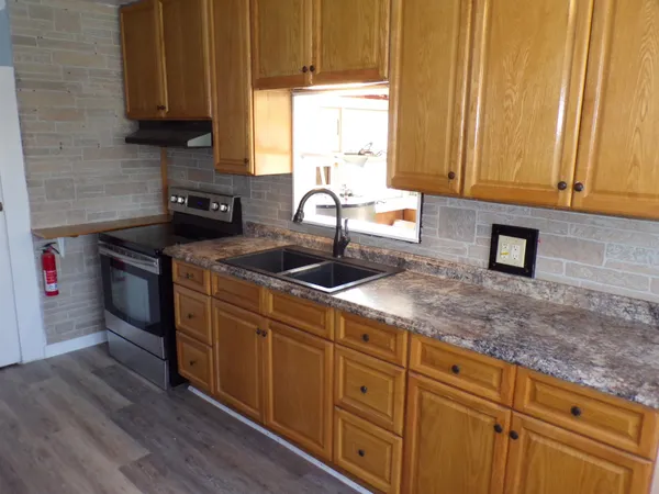 a kitchen with stainless steel appliances granite countertop a sink a stove and cabinets