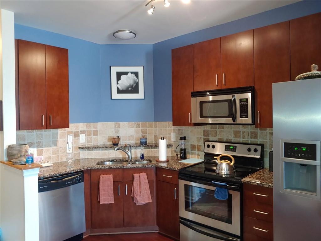898 Oak Street Southwest, Unit 3405 Atlanta, GA 30310 - Photo 2 of 9 a kitchen with stainless steel appliances granite countertop a stove a sink and a microwave
