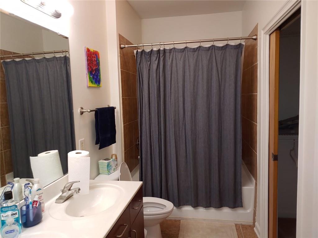 898 Oak Street Southwest, Unit 3405 Atlanta, GA 30310 - Photo 3 of 9 a bathroom with a sink a toilet and shower curtain