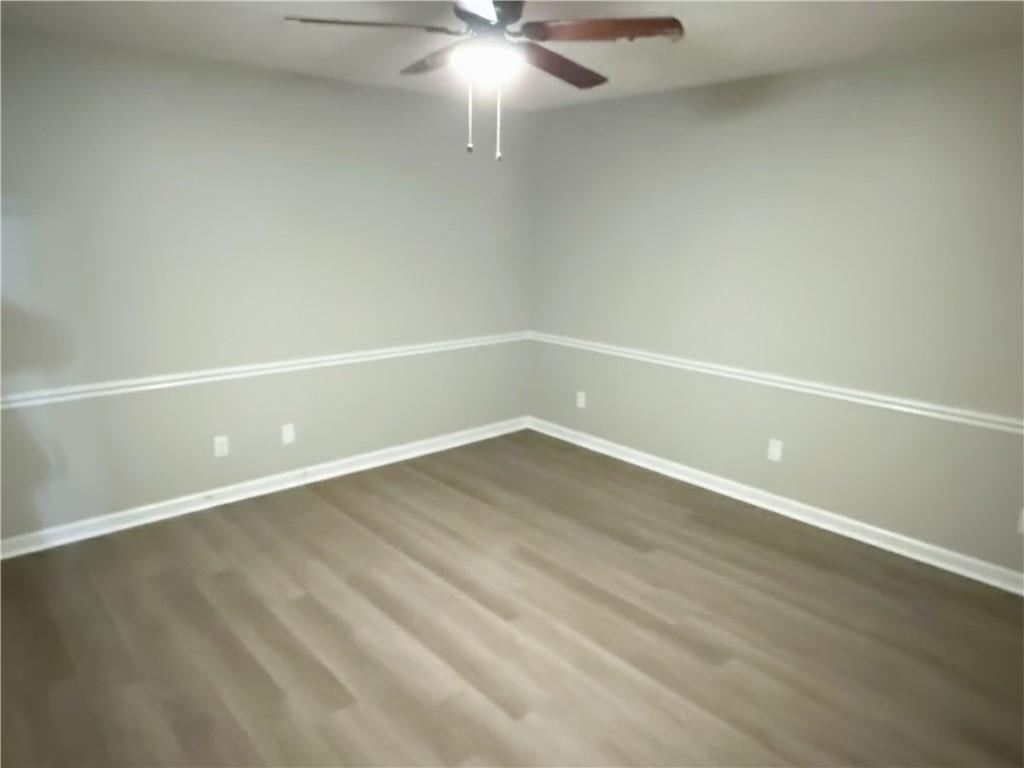 2870 Horseshoe Bend Road Southwest Marietta, GA 30064 - Photo 12 of 21 en empty room with wooden floor and fan