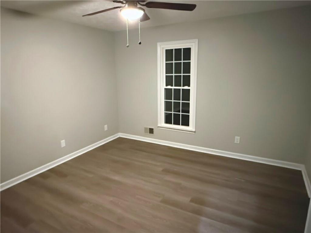 2870 Horseshoe Bend Road Southwest Marietta, GA 30064 - Photo 13 of 21 an empty room with wooden floor cabinets and windows