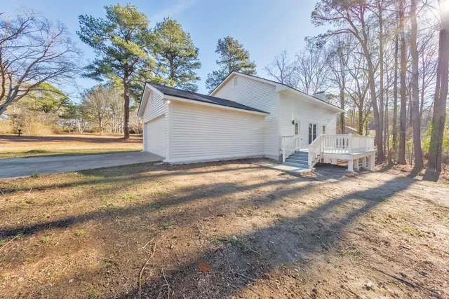 a view of the house with backyard and trees