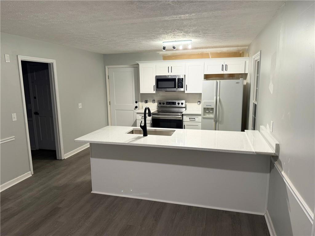 2870 Horseshoe Bend Road Southwest Marietta, GA 30064 - Photo 8 of 21 a kitchen with stainless steel appliances a sink a stove a refrigerator and cabinets