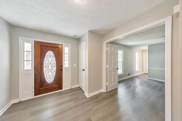 a view of a hallway with entryway with wooden floor