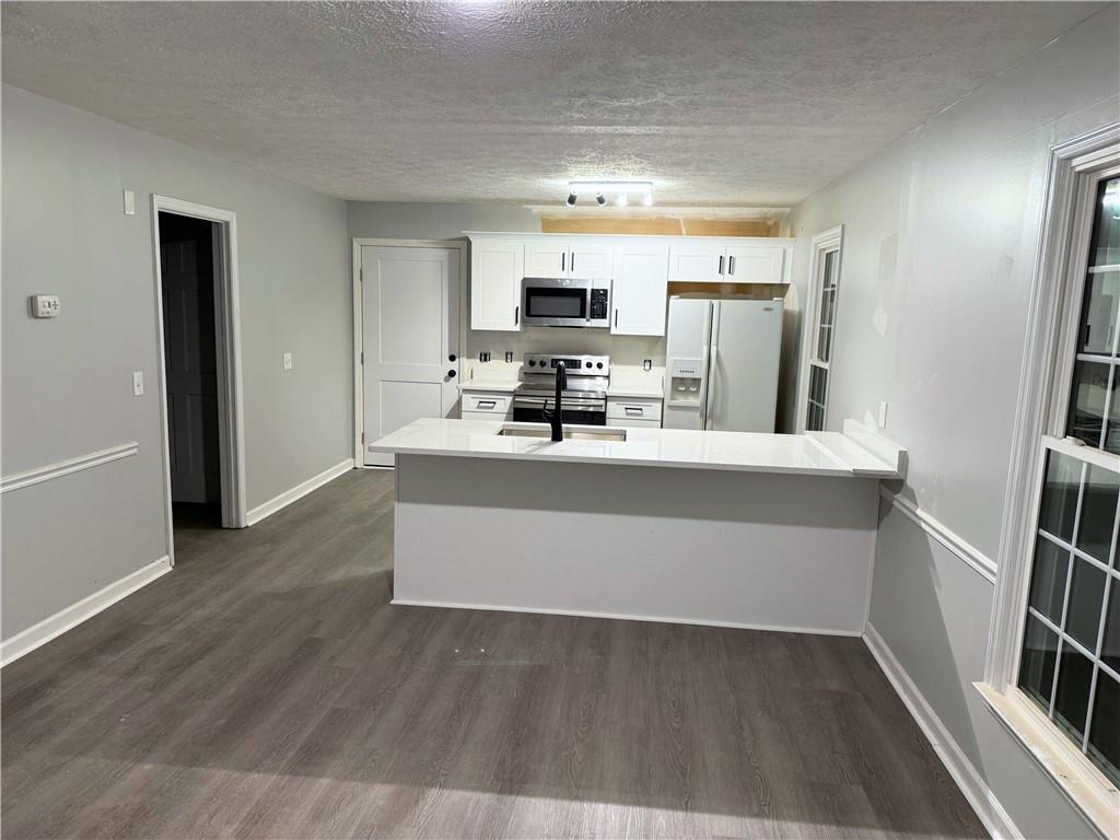 2870 Horseshoe Bend Road Southwest Marietta, GA 30064 - Photo 9 of 21 a room with kitchen island wooden floor and stainless steel appliances