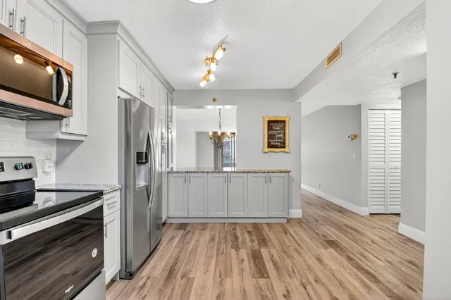 a kitchen with white cabinets and stainless steel appliances