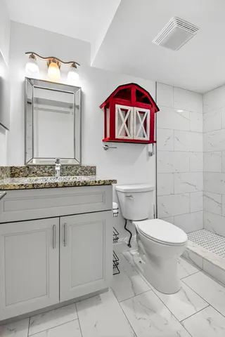 a bathroom with a toilet sink and mirror