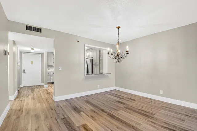 a view of a room with wooden floor and chandelier