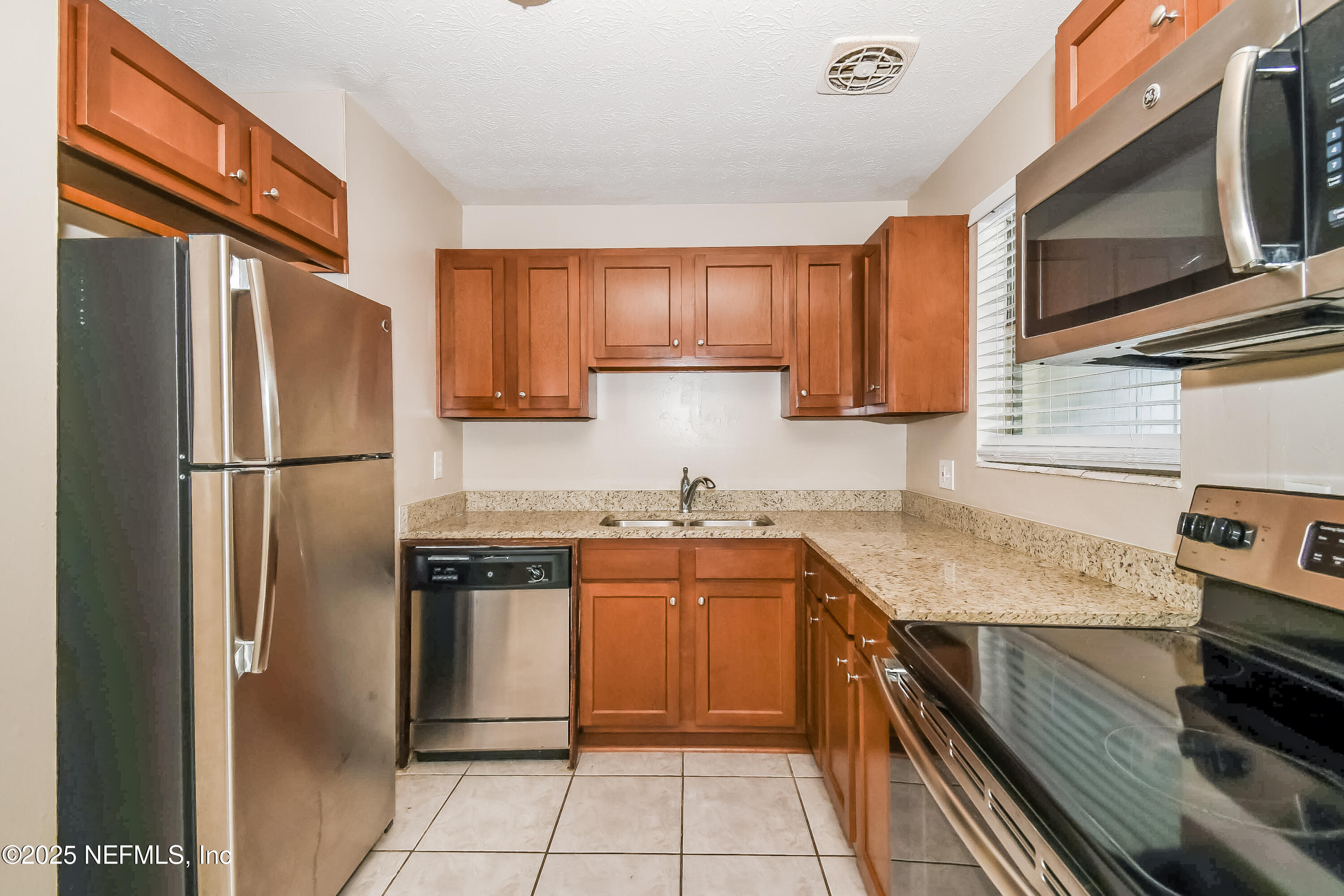 6430 Lucente Drive Jacksonville, FL 32210 - Photo 5 of 15 a kitchen with stainless steel appliances granite countertop a refrigerator stove and sink