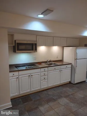 a kitchen with granite countertop white cabinets and stainless steel appliances