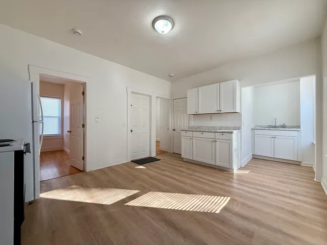 a view of a kitchen with wooden floor and a sink