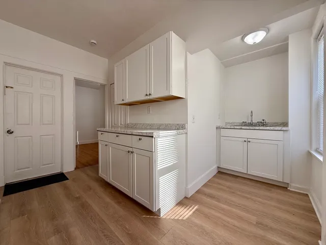 a kitchen with granite countertop white cabinets and white appliances