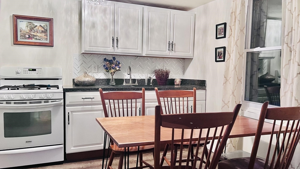 12 Temple Avenue Hudson, MA 01749 - Photo 20 of 32 a kitchen with stainless steel appliances kitchen island a table chairs and a refrigerator