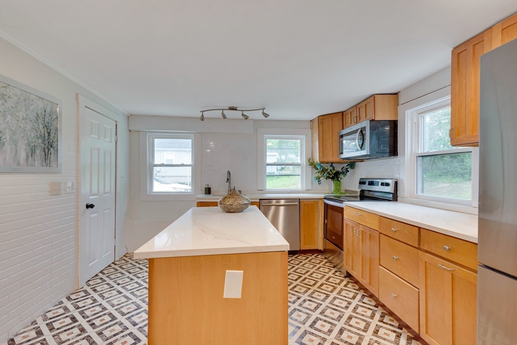 12 Temple Avenue Hudson, MA 01749 - Photo 10 of 32 a kitchen with stainless steel appliances granite countertop a sink stove and refrigerator