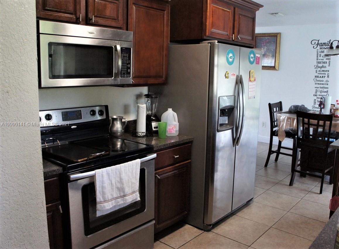 14535 Southwest 297th Terrace Homestead, FL 33033 - Photo 5 of 17 a kitchen with stainless steel appliances granite countertop a stove a refrigerator and a microwave