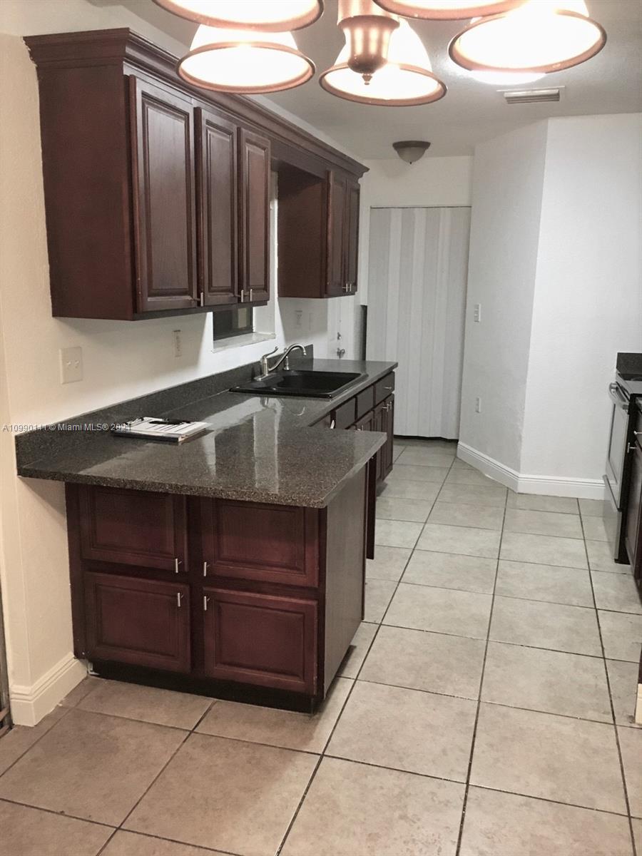14535 Southwest 297th Terrace Homestead, FL 33033 - Photo 6 of 17 a kitchen with a sink and cabinets