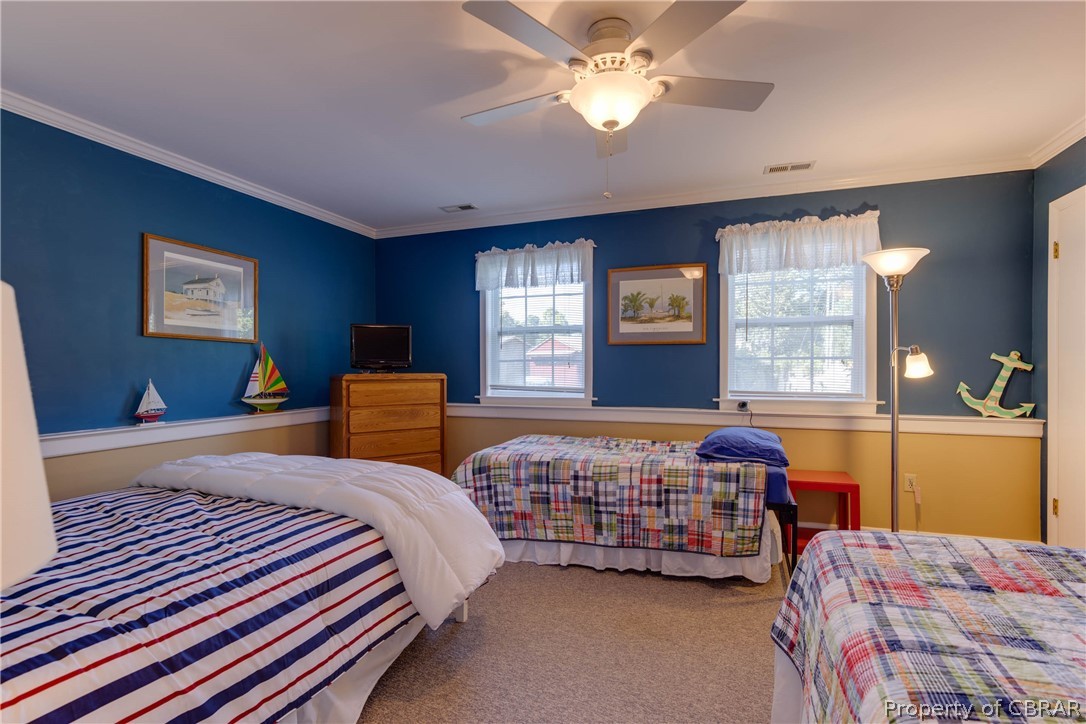 351 Reeves Road Hudgins, VA 23076 - Photo 30 of 41 a bedroom with a bed and a chandelier