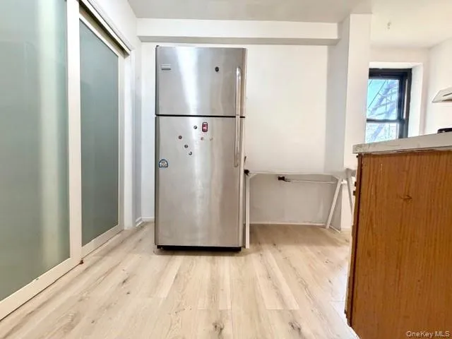 a view of a storage & utility room with refrigerator