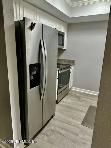 a metallic refrigerator freezer sitting in a kitchen