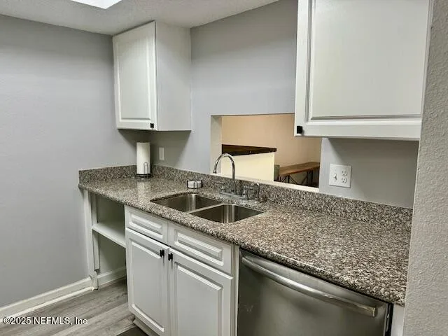 a kitchen with granite countertop a sink and cabinets