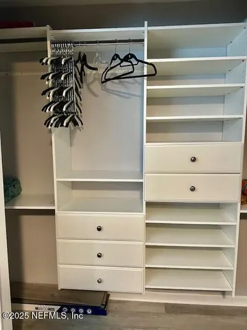 a view of walk in closet with empty racks