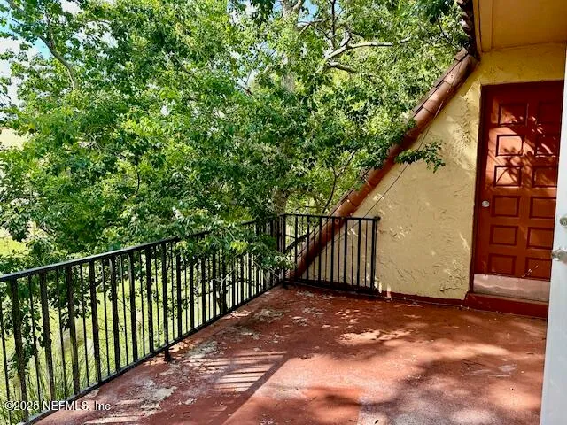 a view of balcony with wooden fence and trees