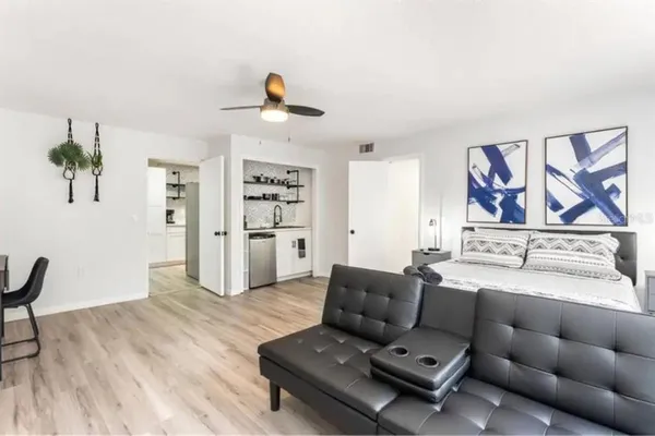 a living room with furniture and a wooden floor