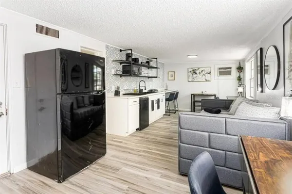 a kitchen with stainless steel appliances kitchen island granite countertop a refrigerator a stove and a sink with wooden floor