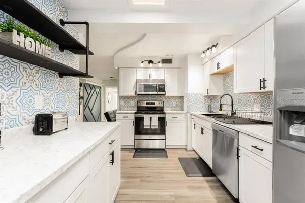 a kitchen with stainless steel appliances granite countertop a stove and a sink