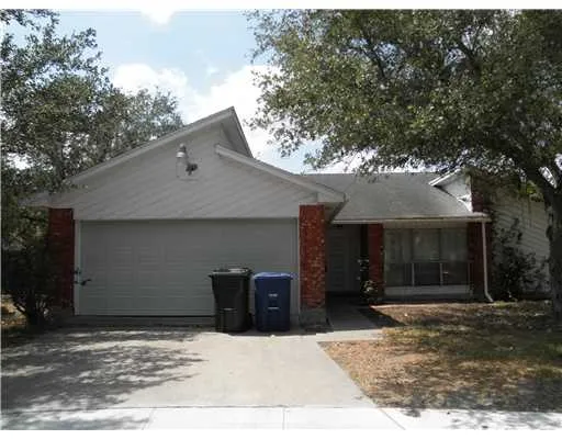 a backyard of a house with large trees and a garage