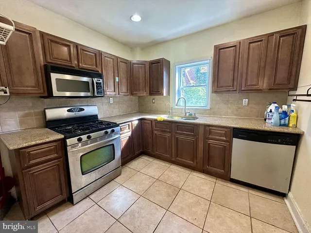a kitchen with stainless steel appliances granite countertop a stove microwave and sink
