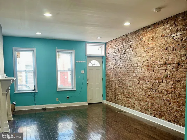 an empty room with wooden floor and a window