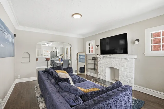 a living room with furniture a flat screen tv and a fireplace