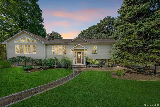 a front view of a house with a yard and trees