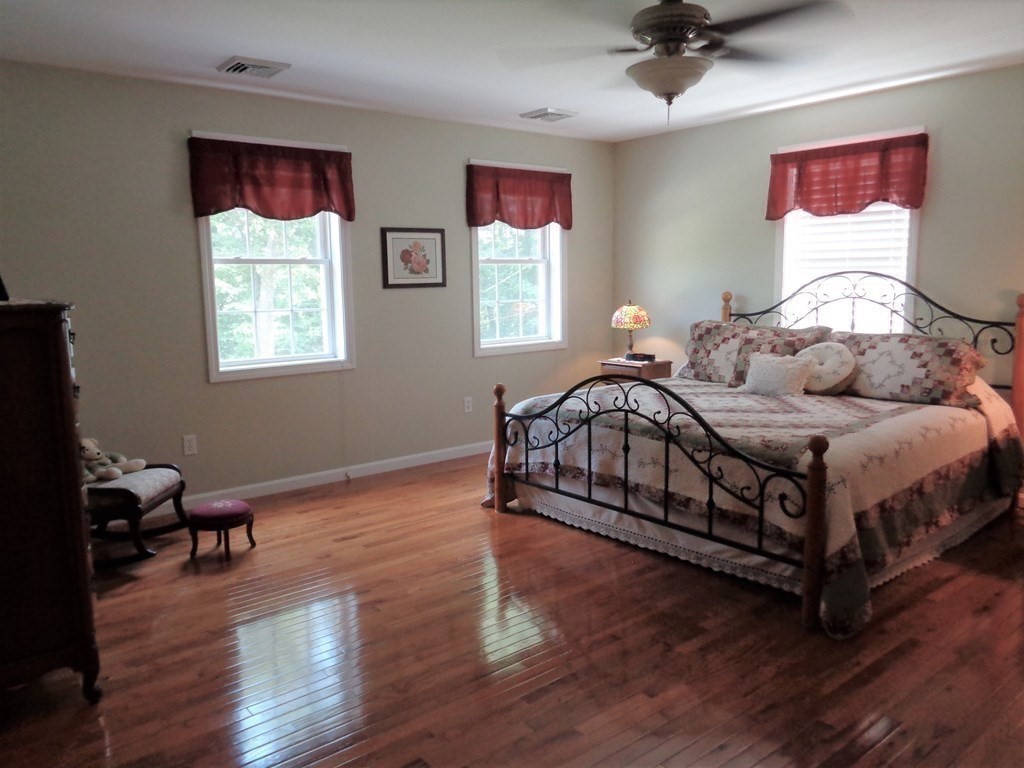 7 R Oxbow Road Oxford, MA 01537 - Photo 25 of 40 a bedroom with a bed and wooden floor